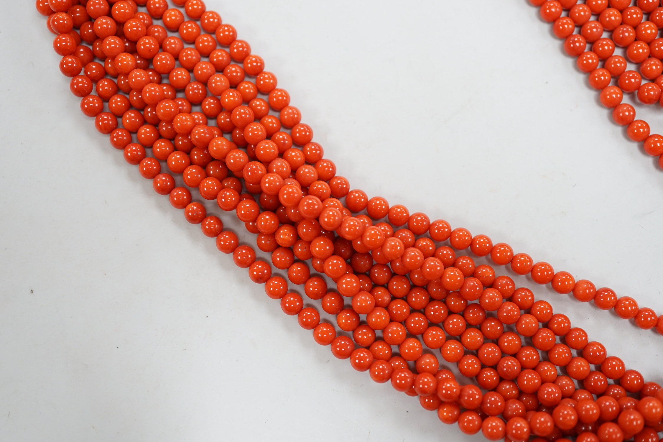 A 1980's Italian multi strand coral bead necklace, with 750 yellow metal clasp and Certificate of Authenticity, 50cm.